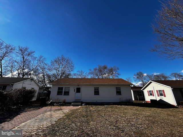 ranch-style house with entry steps and a front lawn