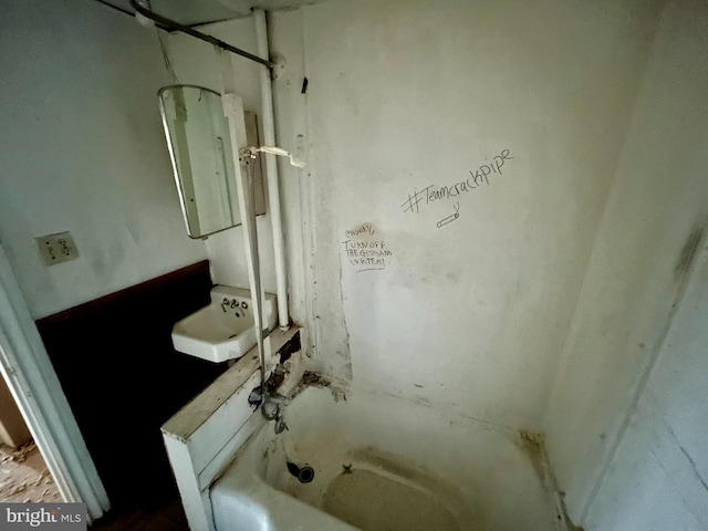 bathroom with a washtub and a sink