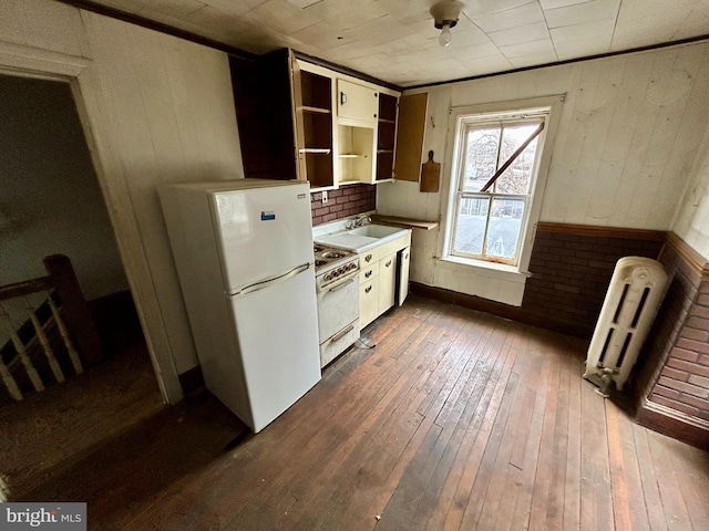 kitchen with dark wood-style floors, open shelves, light countertops, radiator heating unit, and white appliances