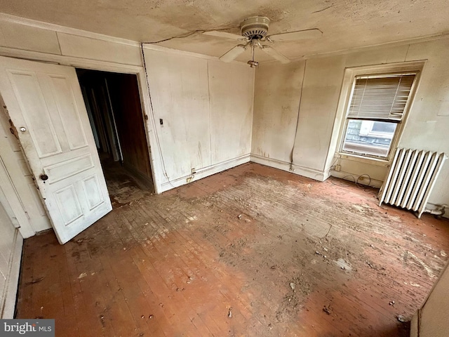 unfurnished bedroom with radiator and wood finished floors