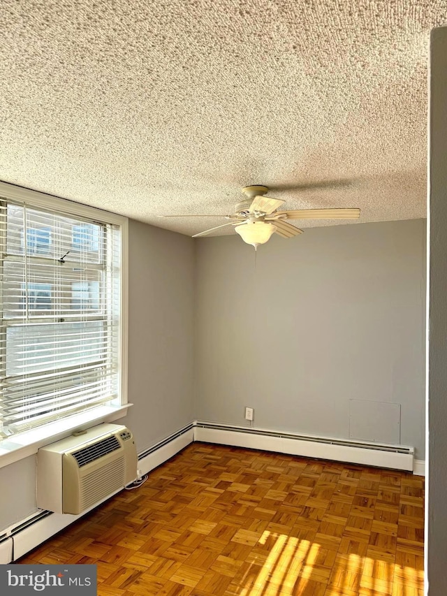 spare room with ceiling fan, a baseboard heating unit, and a textured ceiling