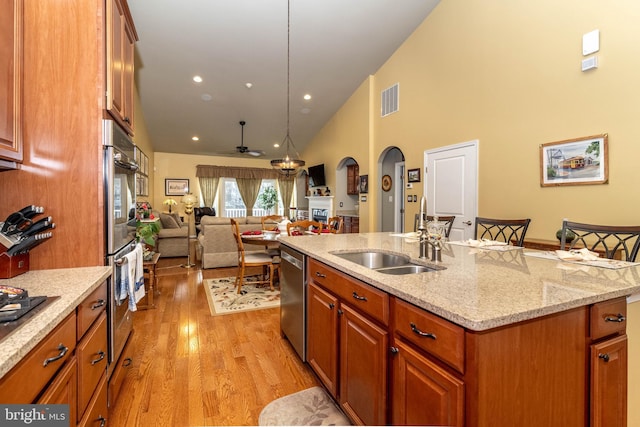 kitchen with a sink, visible vents, open floor plan, appliances with stainless steel finishes, and an island with sink