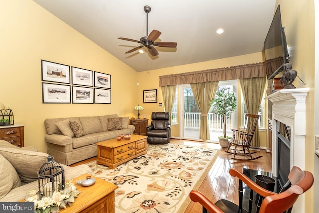 living room featuring a fireplace, lofted ceiling, recessed lighting, light wood-style flooring, and ceiling fan