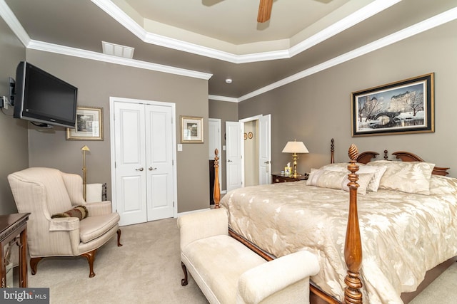 bedroom featuring crown molding, a closet, a raised ceiling, and light colored carpet