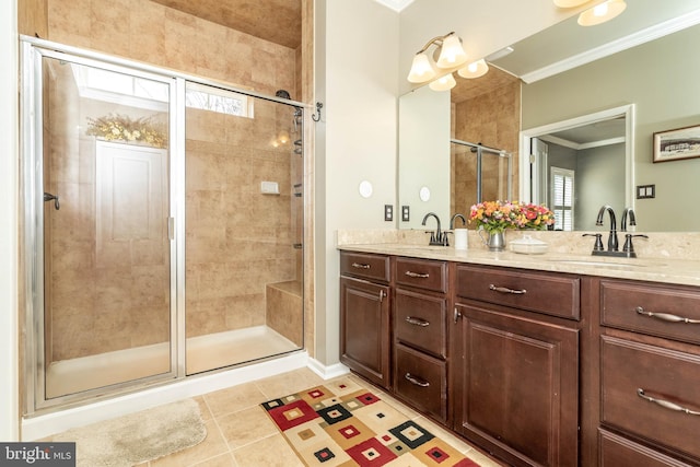 bathroom with crown molding, double vanity, a sink, a shower stall, and tile patterned flooring