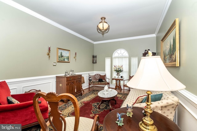 living area featuring a wainscoted wall and crown molding