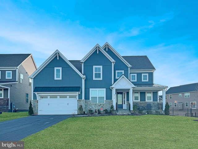 craftsman-style house featuring metal roof, aphalt driveway, roof with shingles, a standing seam roof, and a front yard