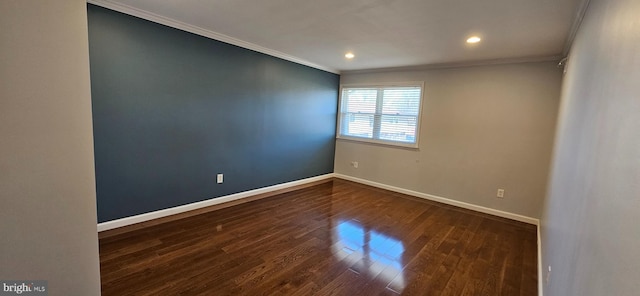 spare room with dark wood-style floors, baseboards, and ornamental molding