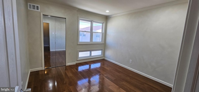 unfurnished bedroom featuring dark wood-style floors, baseboards, visible vents, and crown molding