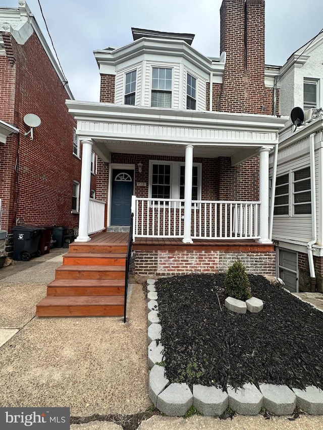 view of front facade featuring covered porch and brick siding