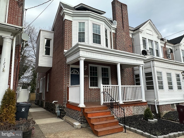 view of front facade with a porch and brick siding