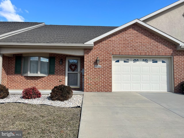 single story home featuring a garage, driveway, brick siding, and roof with shingles