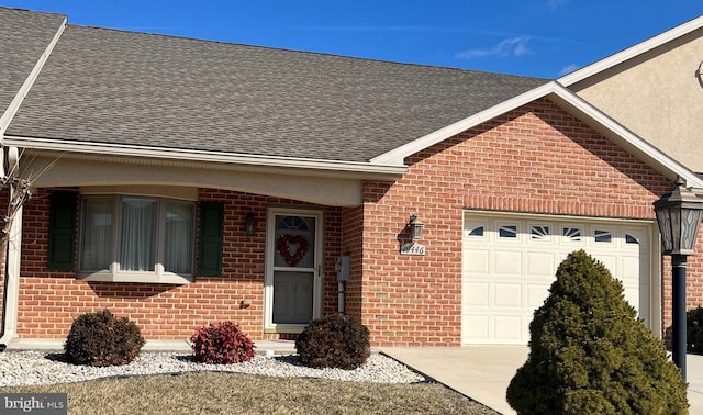 ranch-style house with a garage, brick siding, and a shingled roof