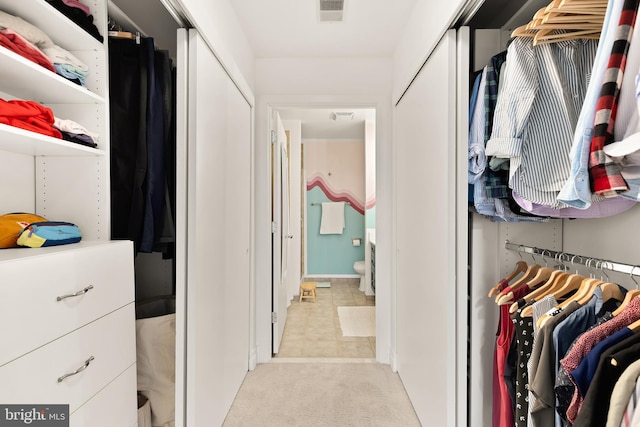 spacious closet featuring visible vents and light colored carpet