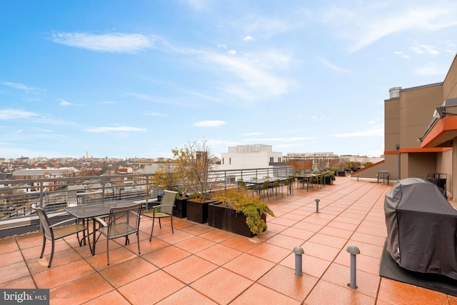 view of patio / terrace featuring a city view, a grill, outdoor dining area, and a balcony