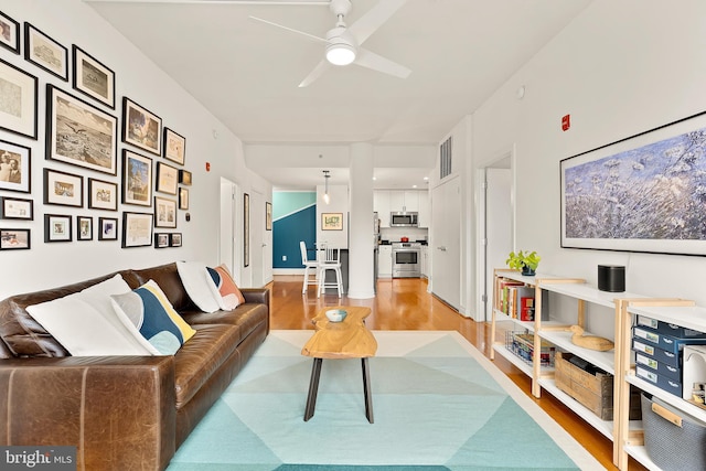 living area featuring visible vents, light wood-style flooring, and a ceiling fan