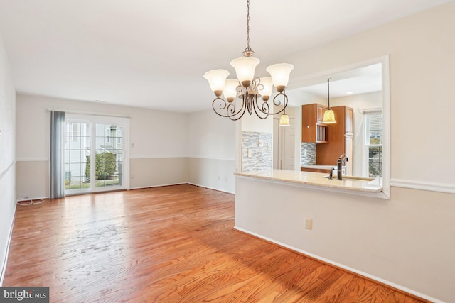 interior space with a notable chandelier, light wood-style flooring, and a sink