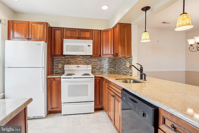 kitchen featuring white appliances, brown cabinets, visible vents, and a sink