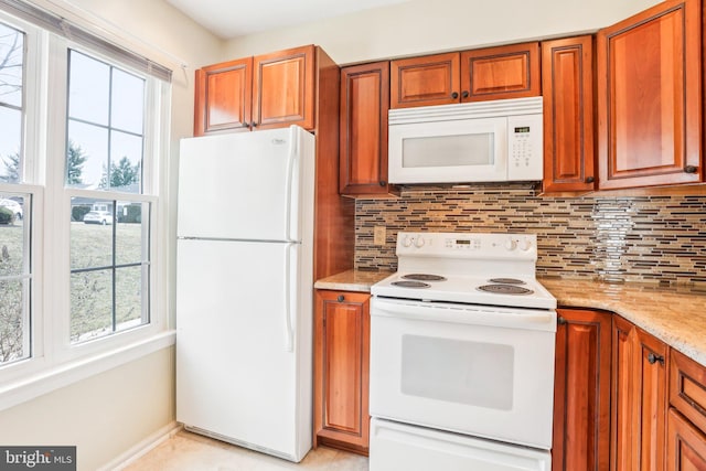 kitchen featuring white appliances, a healthy amount of sunlight, and backsplash