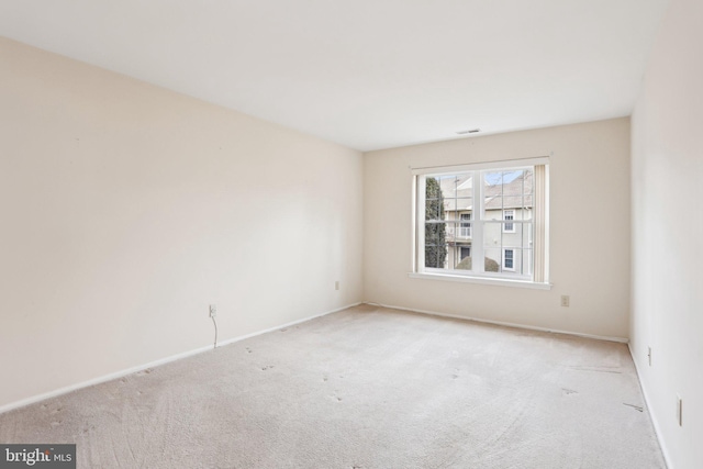 unfurnished room featuring light carpet, visible vents, and baseboards