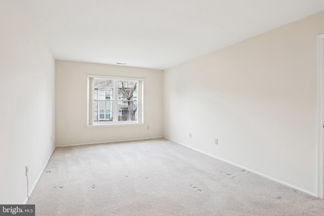 carpeted empty room featuring baseboards