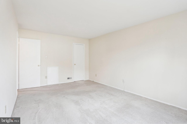 spare room featuring light colored carpet