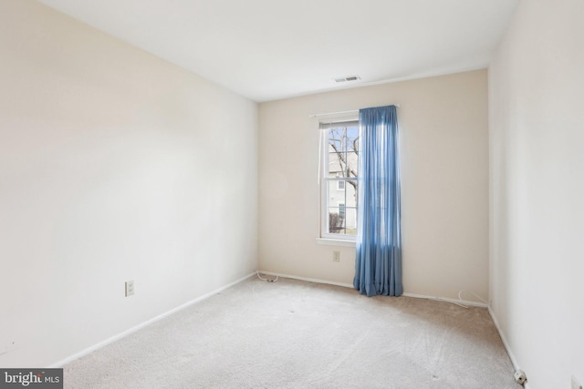 carpeted empty room featuring visible vents and baseboards