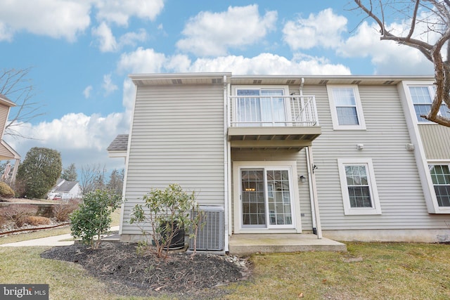 rear view of property featuring central air condition unit and a balcony