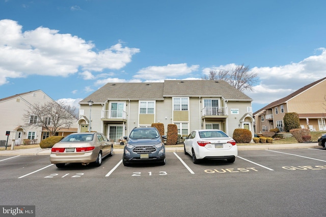 view of building exterior featuring uncovered parking and a residential view