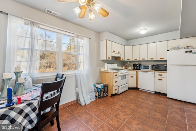 kitchen with ceiling fan, under cabinet range hood, white appliances, visible vents, and white cabinetry