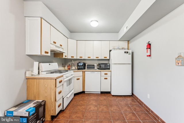 kitchen featuring light countertops, white cabinets, dark tile patterned flooring, white appliances, and under cabinet range hood