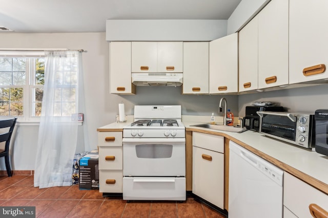 kitchen with under cabinet range hood, white appliances, a sink, white cabinets, and light countertops