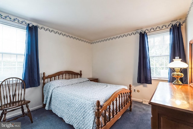 bedroom with baseboards and dark carpet