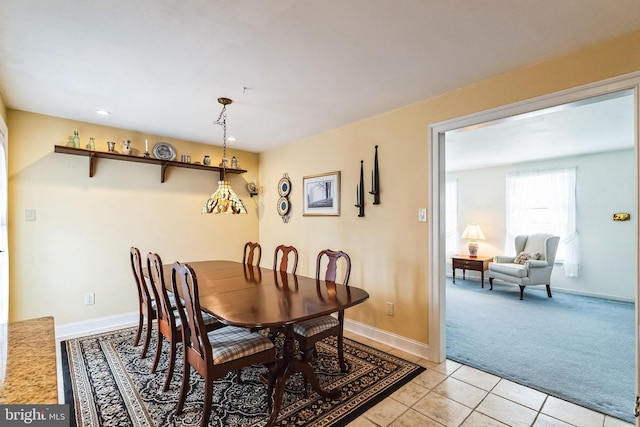 dining space with light tile patterned floors, baseboards, and light colored carpet