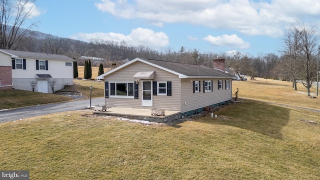 view of front of house with a chimney and a front lawn