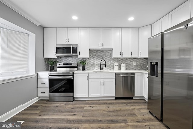 kitchen featuring light countertops, appliances with stainless steel finishes, dark wood-type flooring, and a sink