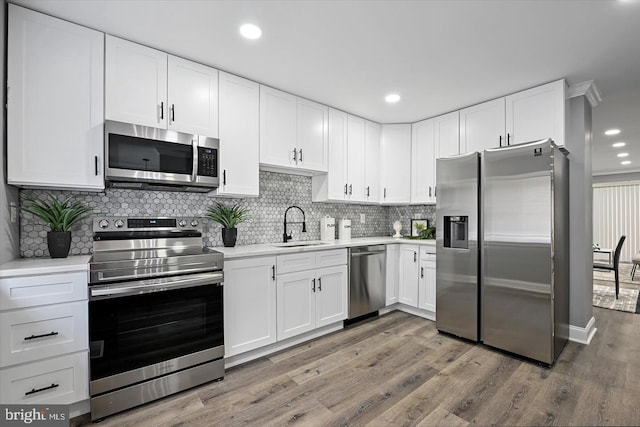 kitchen with white cabinetry, appliances with stainless steel finishes, light countertops, and a sink