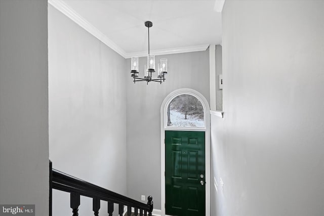 foyer entrance featuring a chandelier and crown molding