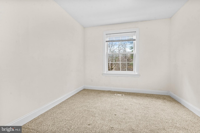 spare room with light carpet, visible vents, and baseboards