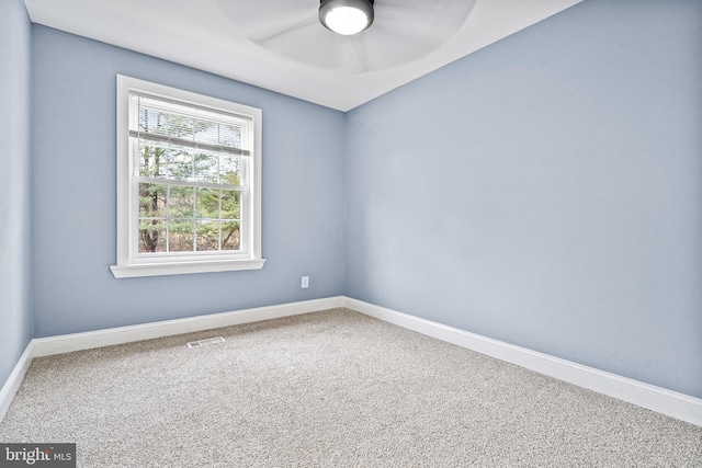 carpeted spare room featuring visible vents and baseboards