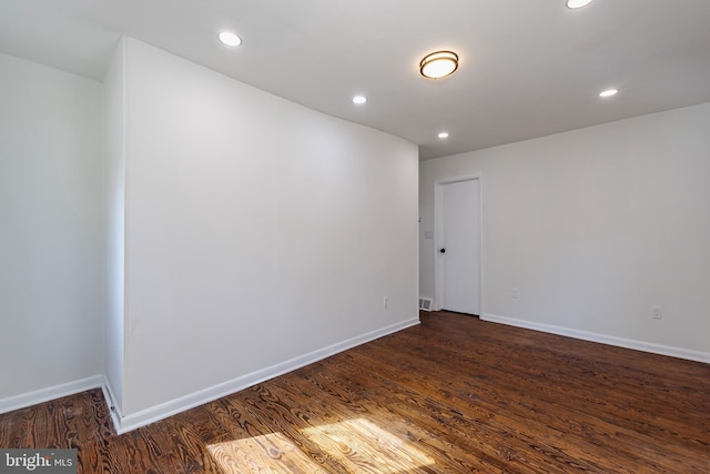 unfurnished room with dark wood-type flooring, recessed lighting, visible vents, and baseboards