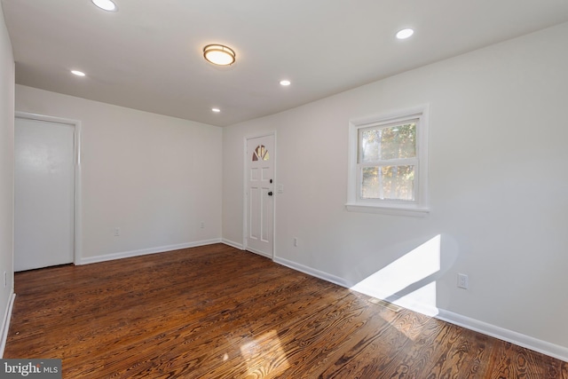 spare room with recessed lighting, dark wood finished floors, and baseboards