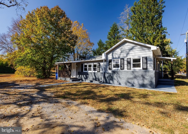 view of front of house with brick siding, a porch, and a front yard