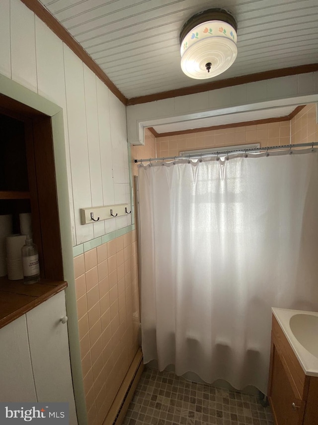 full bath with ornamental molding, tile walls, vanity, and shower / bath combo with shower curtain