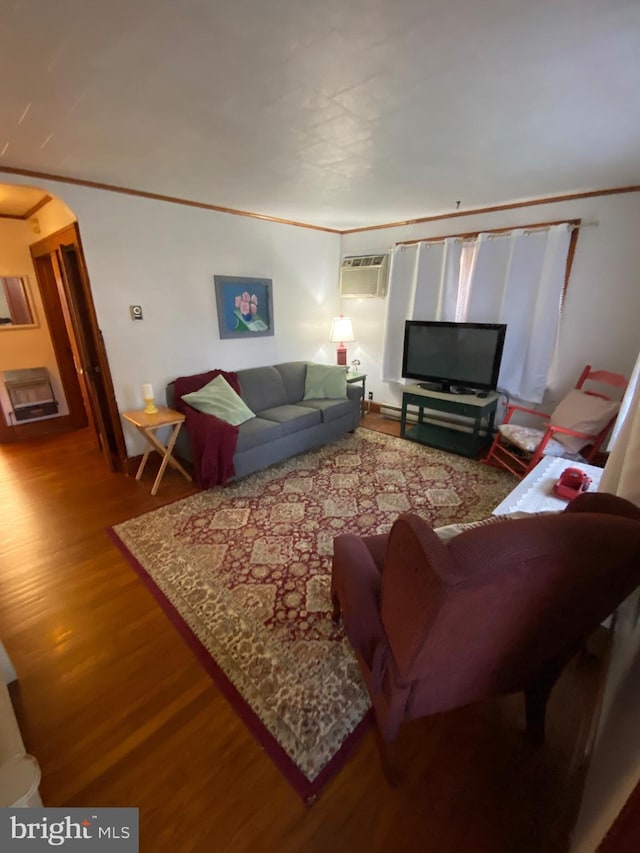 living room featuring ornamental molding, arched walkways, an AC wall unit, and wood finished floors