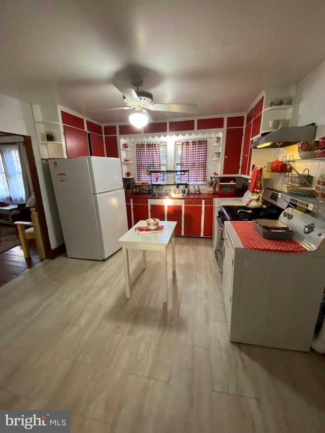 kitchen featuring open shelves, red cabinets, freestanding refrigerator, and stainless steel electric stove