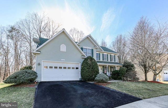 traditional-style home featuring aphalt driveway and a front yard