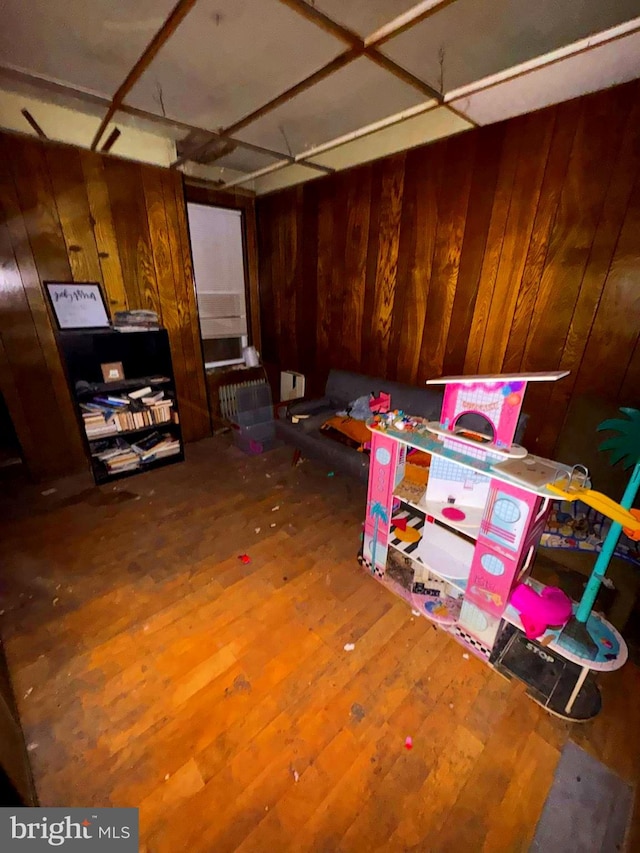 game room featuring wood finished floors and wooden walls