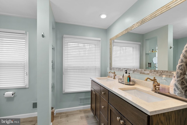 full bathroom featuring visible vents, a sink, baseboards, and wood finished floors