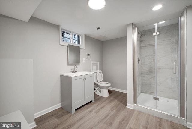 bathroom with baseboards, a shower stall, toilet, and wood finished floors